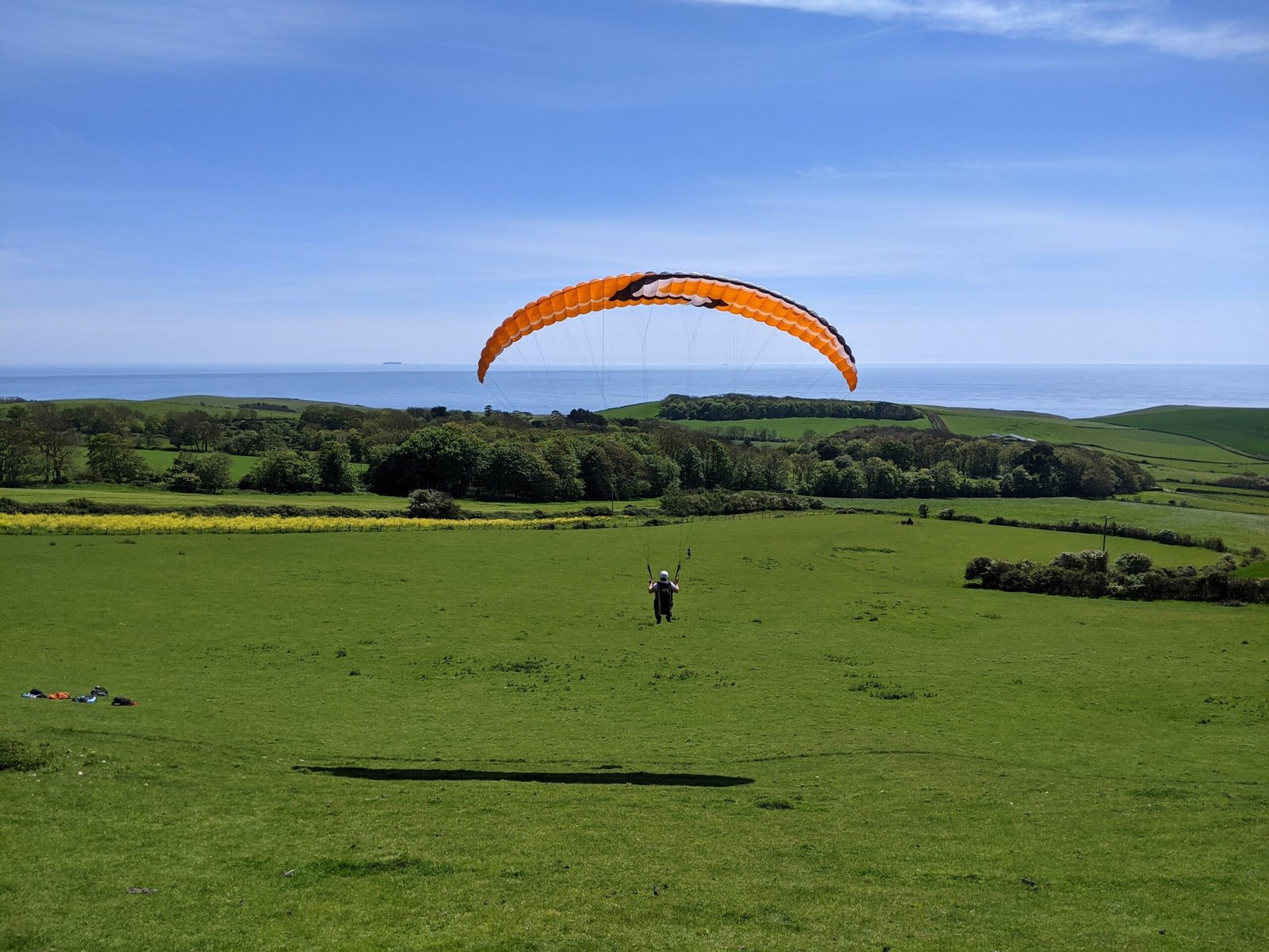 A student completing one of their first flights with Sky riders at Kimmeridge bay on their paragliding elementary pilot course