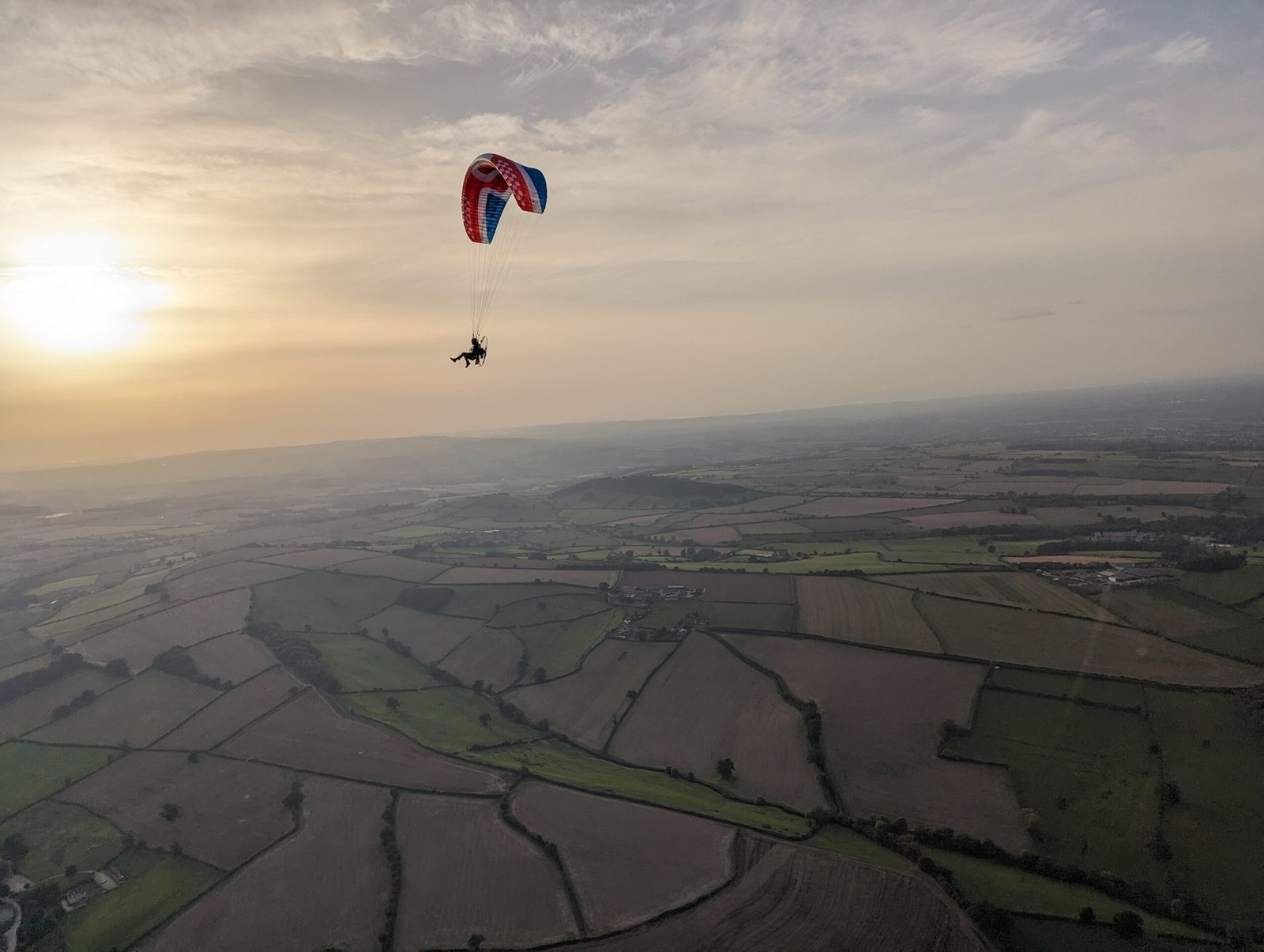 a paramotor soaring through the skies near bath at sunset on a cross country flight with Sky riders paramotor training school