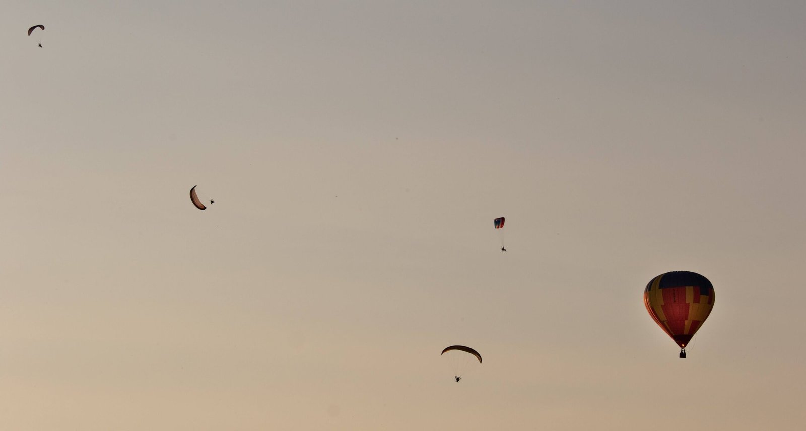 4 paramotors having a blast with a hot air balloon over the somerset levels one summer evening
